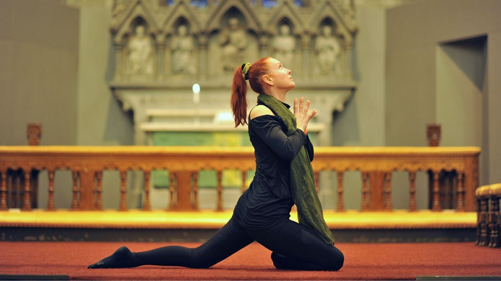kvinne i yogastilling foran alterring i Bergen Domkirke