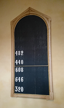 Bilde av en samletavle med salmenumrene. 482, 440, 608, 646 og 320 henge på tavlen
