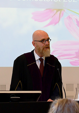 Bildet kan inneholde: briller, mikrofon, podium, synsomsorg, menneskelig.